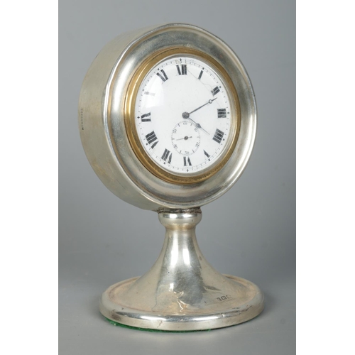 123 - A George V silver desk clock of circular form on pedestal base. Assayed Birmingham 1922 with partial... 