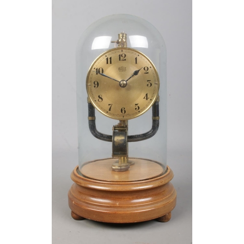 145 - An early 20th century Bulle electro magnetic clock under glass dome, raised on wooden stand. 26.5cm.