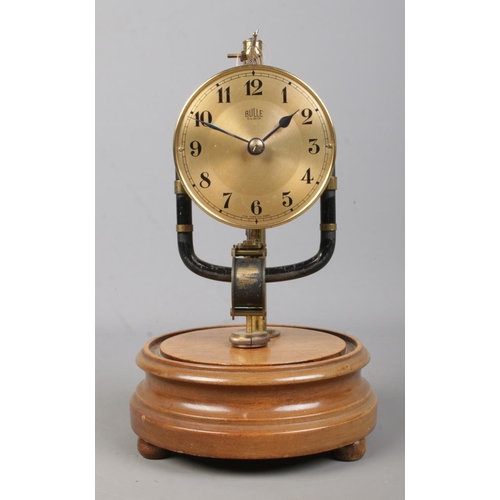 145 - An early 20th century Bulle electro magnetic clock under glass dome, raised on wooden stand. 26.5cm.