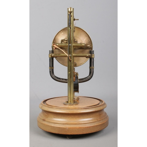 145 - An early 20th century Bulle electro magnetic clock under glass dome, raised on wooden stand. 26.5cm.