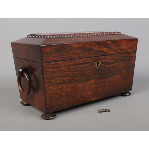 150 - A 19th century rosewood tea caddy of sarcophagus form. Having twin loop handles, fitted interior wit... 