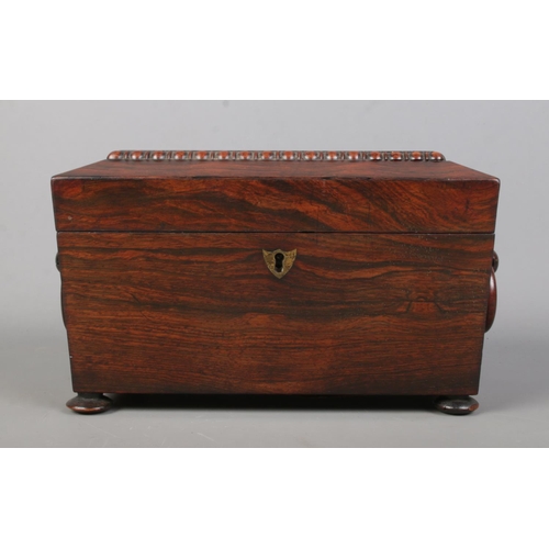 150 - A 19th century rosewood tea caddy of sarcophagus form. Having twin loop handles, fitted interior wit... 