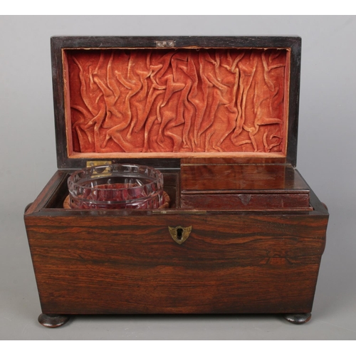 150 - A 19th century rosewood tea caddy of sarcophagus form. Having twin loop handles, fitted interior wit... 