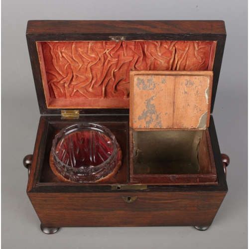 150 - A 19th century rosewood tea caddy of sarcophagus form. Having twin loop handles, fitted interior wit... 