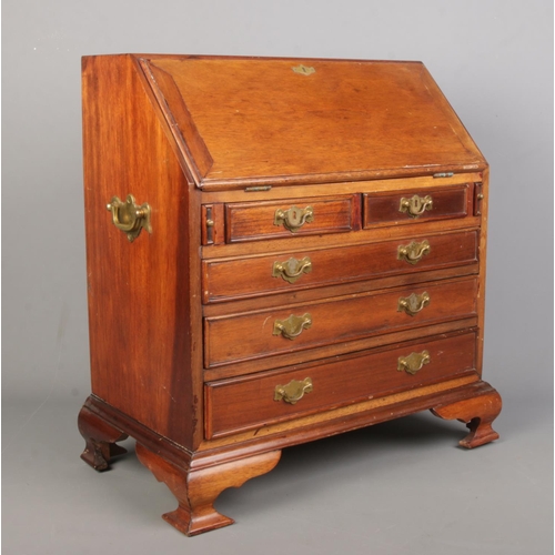 153 - A miniature mahogany bureau in the Georgian style with brass fittings. Height 46.5cm, Width 45cm, De... 