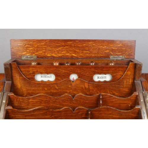 156 - An early 20th century oak desk tidy with fitted interior and perpetual calendar. Height 33cm, Width ... 