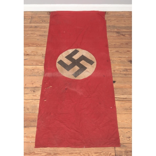 189 - A World War Two period German Nazi Party flag. Red ground with swastika to both sides. 185cm x 72cm.