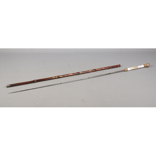 209 - A bamboo cased sword stick. Having porcelain grip, hand painted with Sevres style scenes and gilt me... 