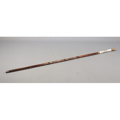 209 - A bamboo cased sword stick. Having porcelain grip, hand painted with Sevres style scenes and gilt me... 