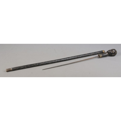 210 - An early 20th century African tribal sword stick with carved bust pommel. Length 94cm. CANNOT POST O... 