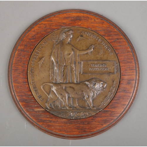 212 - A World War One bronze memorial plaque/death penny awarded to Edmund Parkinson. In wooden frame.