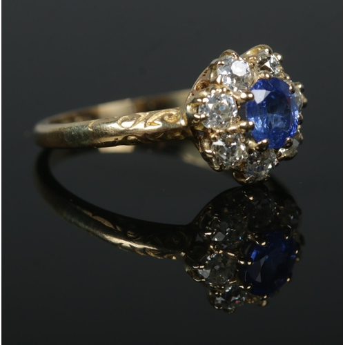 242 - A Victorian 18ct gold sapphire and diamond halo cluster ring. Central stone approximately 0.5ct. Siz... 