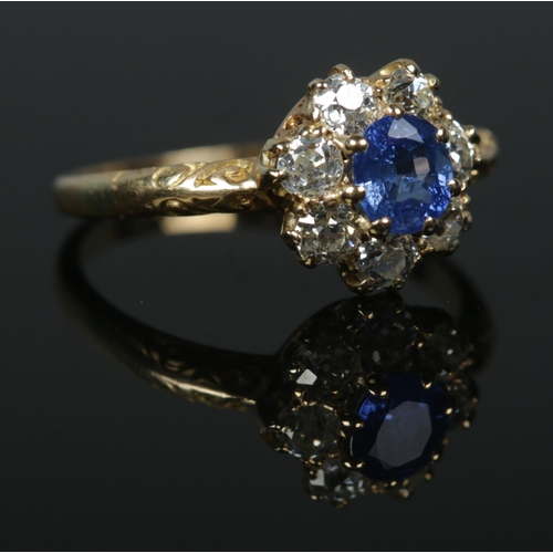 242 - A Victorian 18ct gold sapphire and diamond halo cluster ring. Central stone approximately 0.5ct. Siz... 