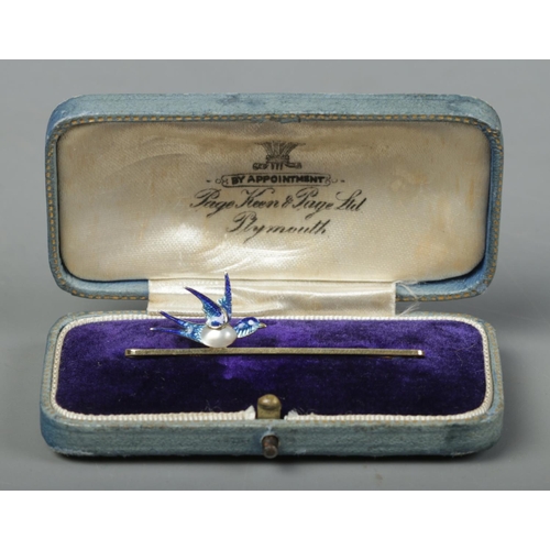 243 - A 15ct gold bar brooch surmounted with a blister pearl and enamel bird. Length 5cm. 3.43g.