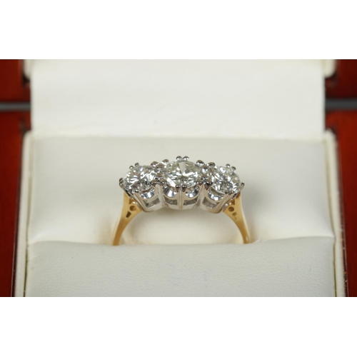 251 - An 18ct gold three stone diamond ring. Approximately 1.9ct diamond in total. Has original sale recei... 