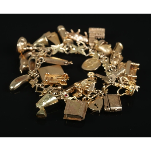 252 - A 9ct gold charm bracelet with floral and paste set links and contents of mostly 9ct gold charms. To... 