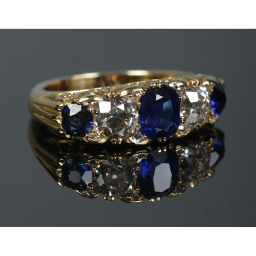 A gold, diamond and sapphire five stone ring. Each diamond just over 1ct. Tests as high carat gold. Size P. 11.22g.