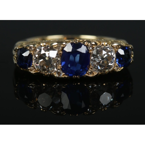 253 - A gold, diamond and sapphire five stone ring. Each diamond just over 1ct. Tests as high carat gold. ... 