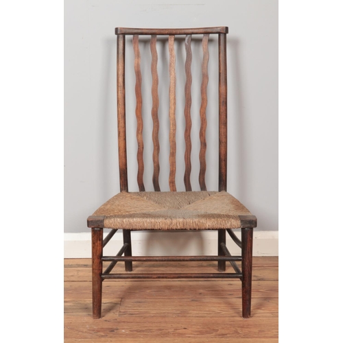 280 - An Arts & Crafts Liberty & Co rush seat chair. Height of back 86cm.