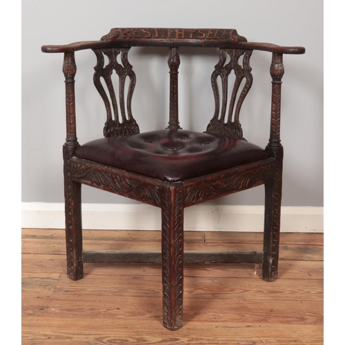 281 - An early 20th century oak corner chair with carved decoration and 'Rest Thy Self' to the back rest.