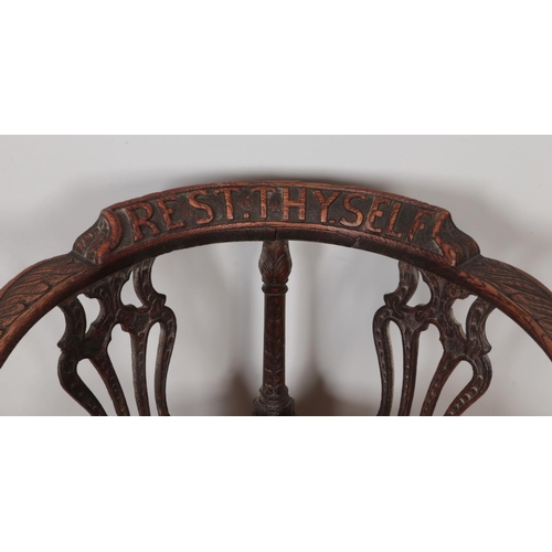 281 - An early 20th century oak corner chair with carved decoration and 'Rest Thy Self' to the back rest.