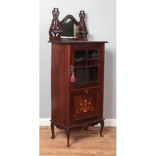 297 - An Edwardian mahogany music cabinet. Having mirrored back, glazed front and inlaid drop down bottom.... 