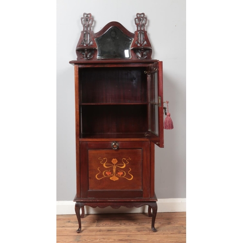 297 - An Edwardian mahogany music cabinet. Having mirrored back, glazed front and inlaid drop down bottom.... 