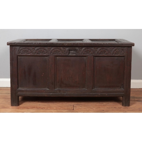 299 - An antique carved and panelled oak coffer. Height 58cm, Width 111cm, Depth 52cm.