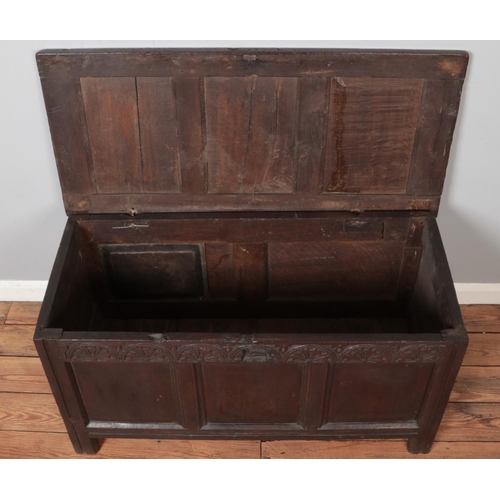 299 - An antique carved and panelled oak coffer. Height 58cm, Width 111cm, Depth 52cm.