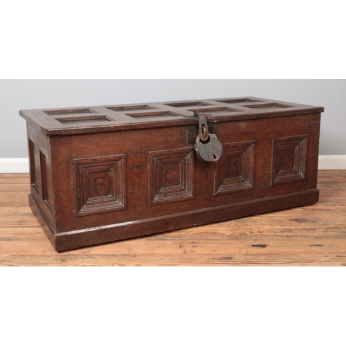 301 - An antique panelled oak coffer. Carved to the front with initials FC and dated 1589. Height 51cm, Wi... 