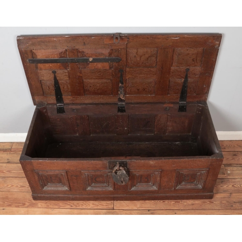 301 - An antique panelled oak coffer. Carved to the front with initials FC and dated 1589. Height 51cm, Wi... 