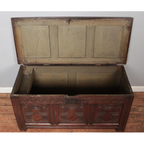 304 - An antique carved oak coffer. Height 62cm, Width 134cm, Depth 59cm.