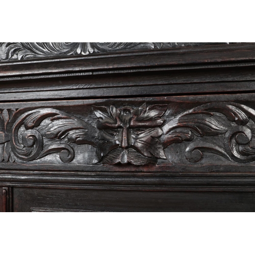 306 - An ebonised mirror back sideboard with floral and green man carved decoration.