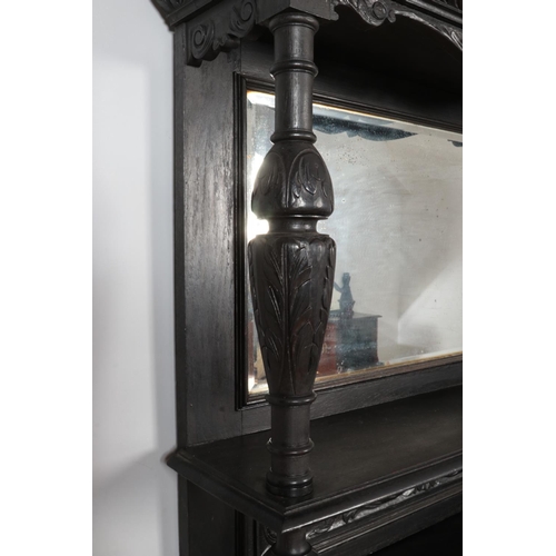 306 - An ebonised mirror back sideboard with floral and green man carved decoration.