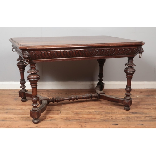 308 - A carved oak table with lion mask decoration to all four corners. Height 73cm, Top 90cm x 123cm.