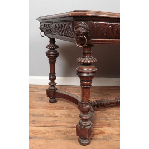 308 - A carved oak table with lion mask decoration to all four corners. Height 73cm, Top 90cm x 123cm.