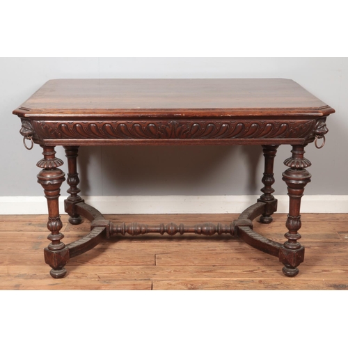 308 - A carved oak table with lion mask decoration to all four corners. Height 73cm, Top 90cm x 123cm.