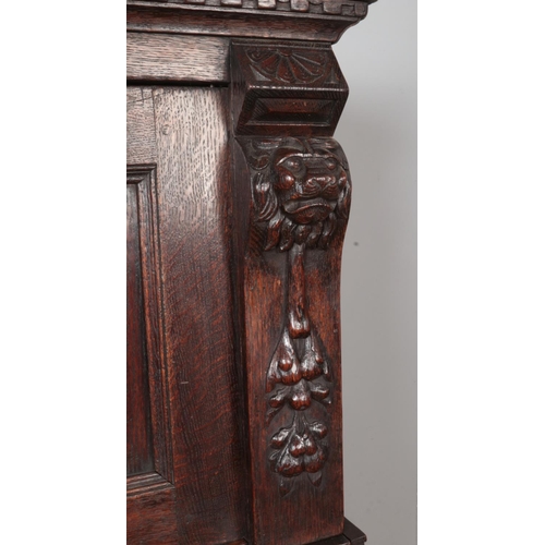 309 - A carved and panelled oak Flemish cabinet. Height 177cm, Width 135cm, Depth 64cm.