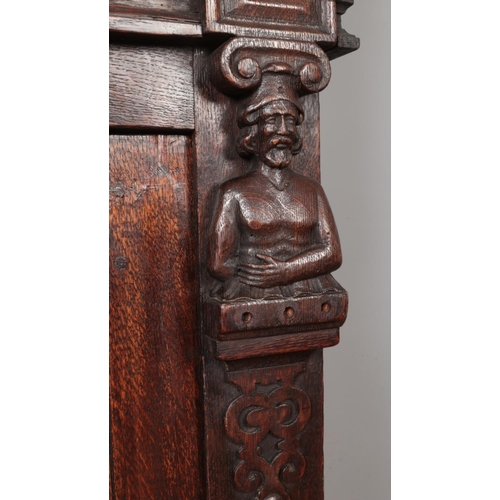 309 - A carved and panelled oak Flemish cabinet. Height 177cm, Width 135cm, Depth 64cm.