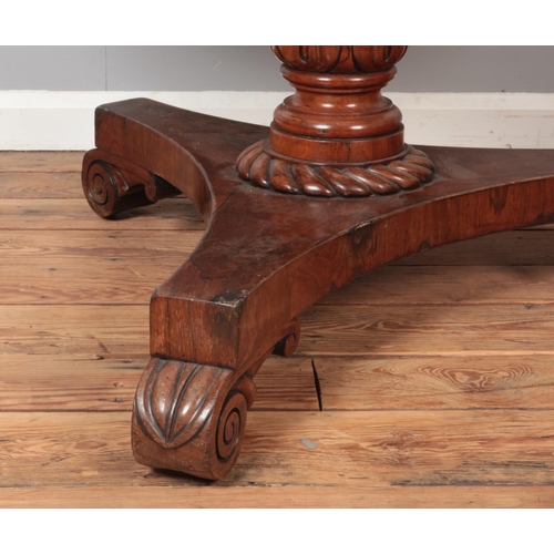 312 - A Victorian rosewood supper table with circular top and carved triform base. Diameter 107cm.