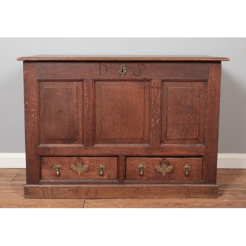 319 - A 19th century oak mule chest with triple panelled front and two drawers with tear drop handles and ... 