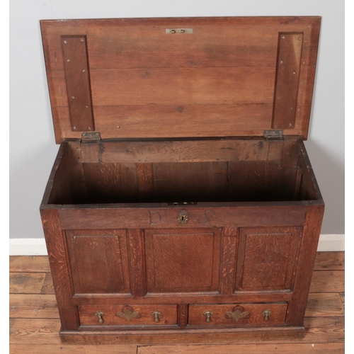 319 - A 19th century oak mule chest with triple panelled front and two drawers with tear drop handles and ... 