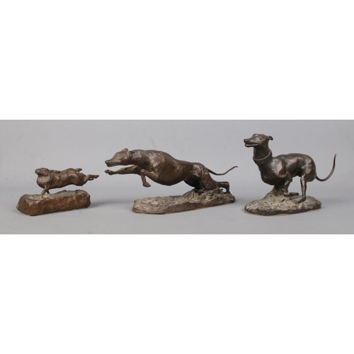 63 - Michael Lyne, a set of three bronze sculptures modelled as two coursing dogs chasing a hare. All sig... 