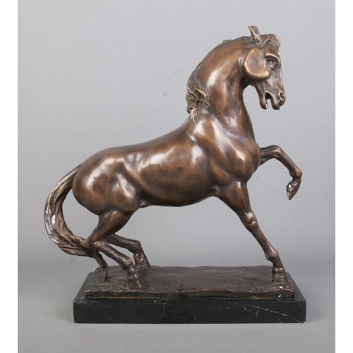 65 - After Anoine-Louis Barye, a bronze sculpture of a prancing horse, raised on marble base. Height 33cm... 