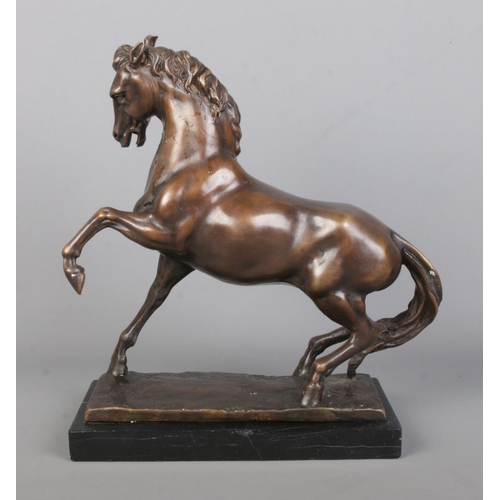 65 - After Anoine-Louis Barye, a bronze sculpture of a prancing horse, raised on marble base. Height 33cm... 