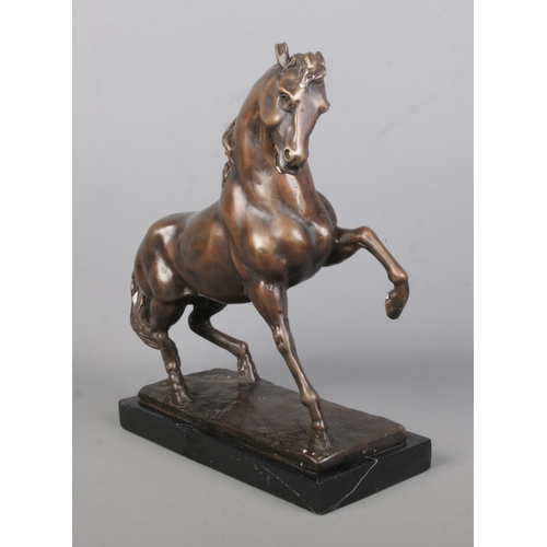 65 - After Anoine-Louis Barye, a bronze sculpture of a prancing horse, raised on marble base. Height 33cm... 