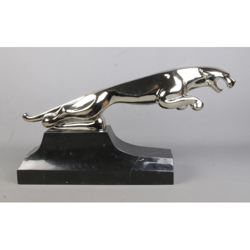 66 - A large cast white metal sculpture of a Jaguar raised on marble base. Length 68cm, Height 34cm.