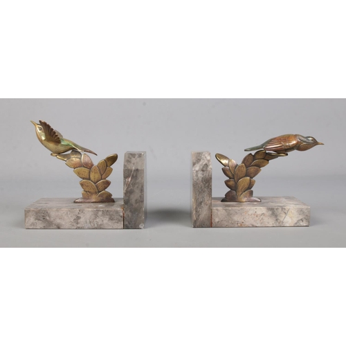 71 - A pair of bronze and marble book ends, surmounted with exotic birds.