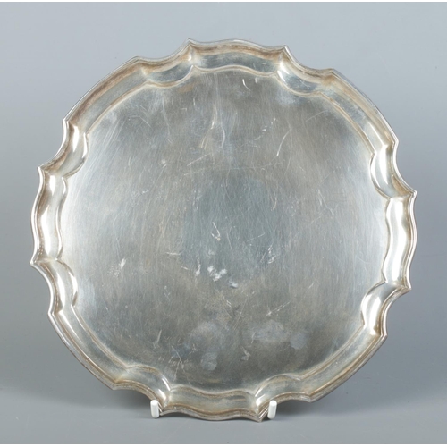 88 - A silver salver raised on four scrolled feet. Assayed Sheffield 1967 by James Dixon & Sons Ltd. Diam... 