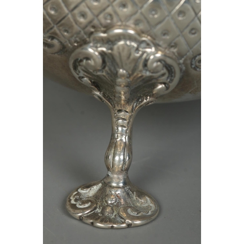 92 - A Victorian silver cream jug with repousse decoration, scrolling handle and raised on three hoof fee... 